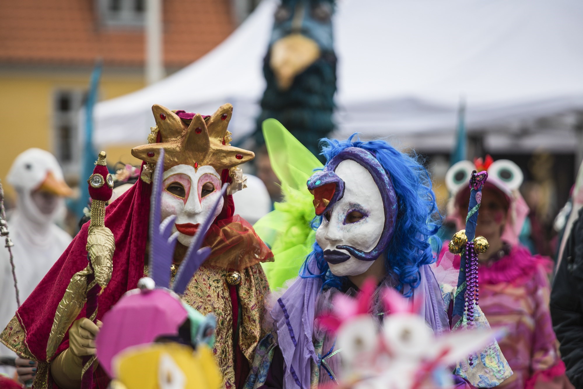 To personer med karnevalsmasker og farvestrålende tøj