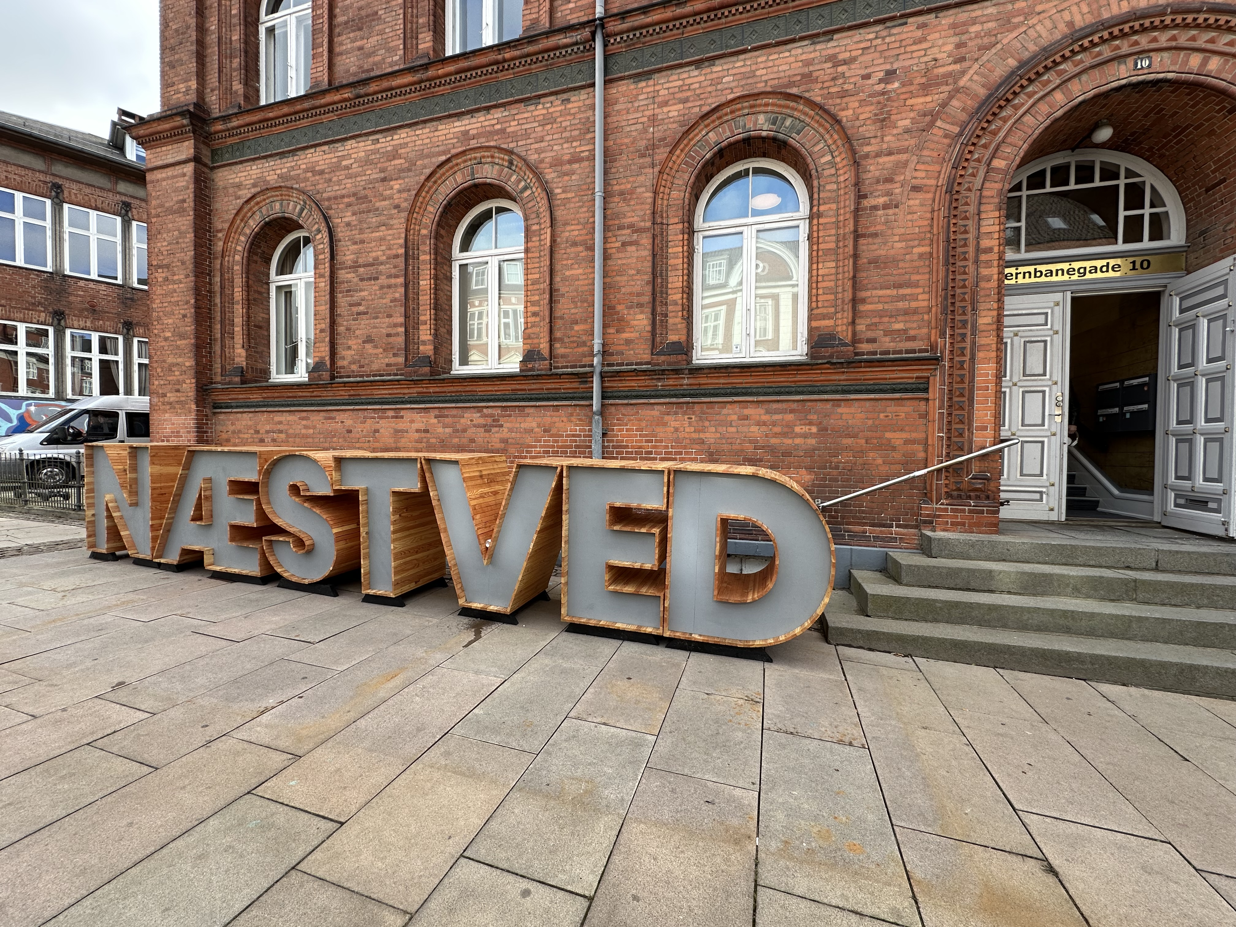 Gammel murstensbygning med bogstaver foran, hvor der står NÆSTVED.