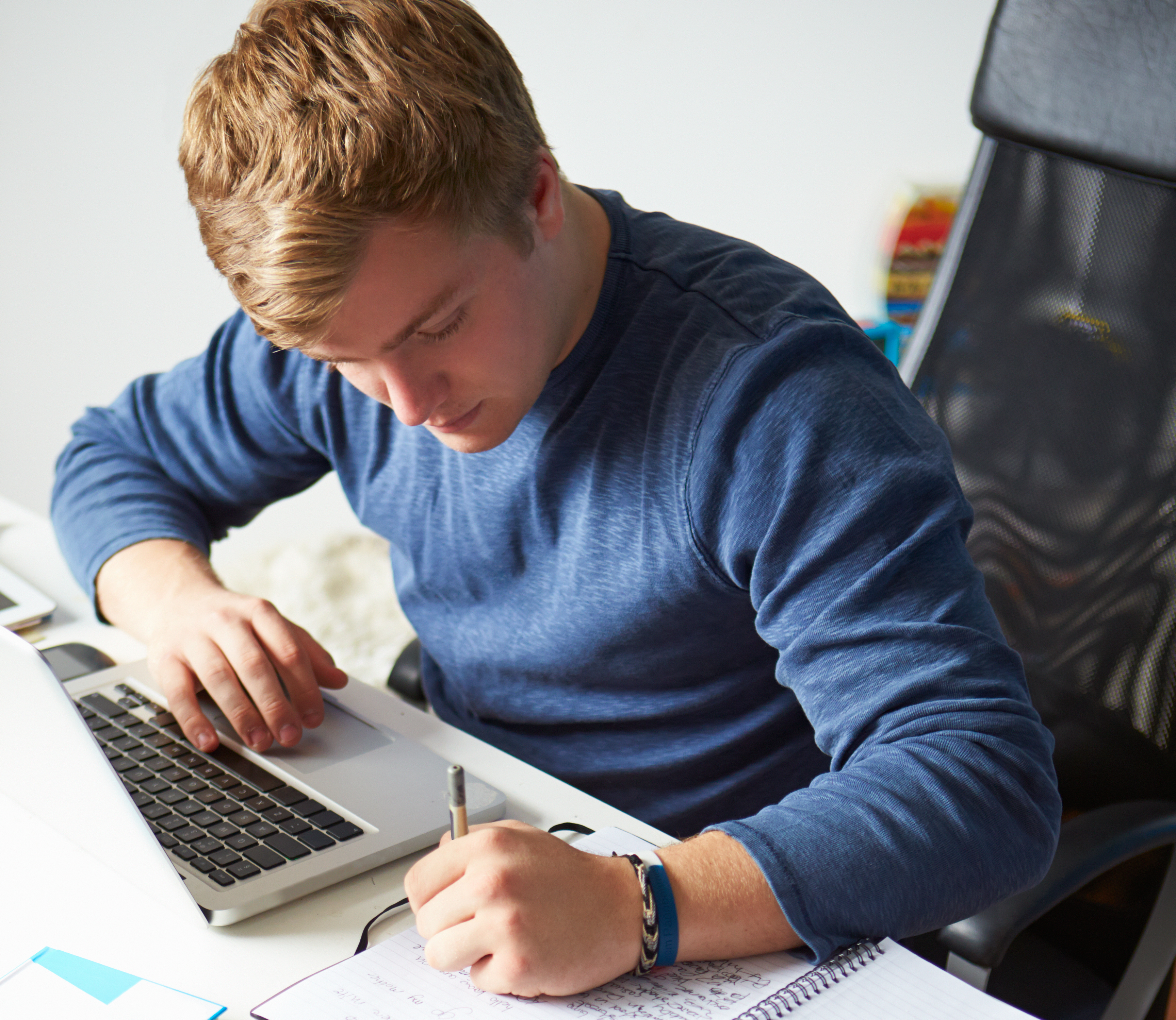 På billedet ses en mand ved en pc. Han noterer i en blok