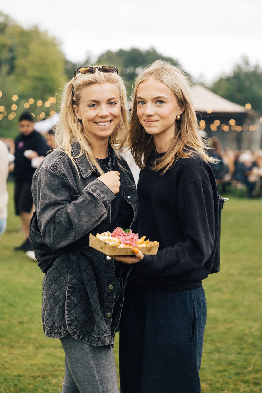 To unge kvinder med en bakke mad fra en streetfood vogn i hånden. 