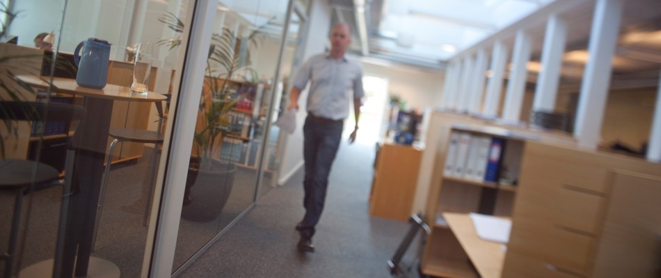 En mand går på gangen i en kontormiljø