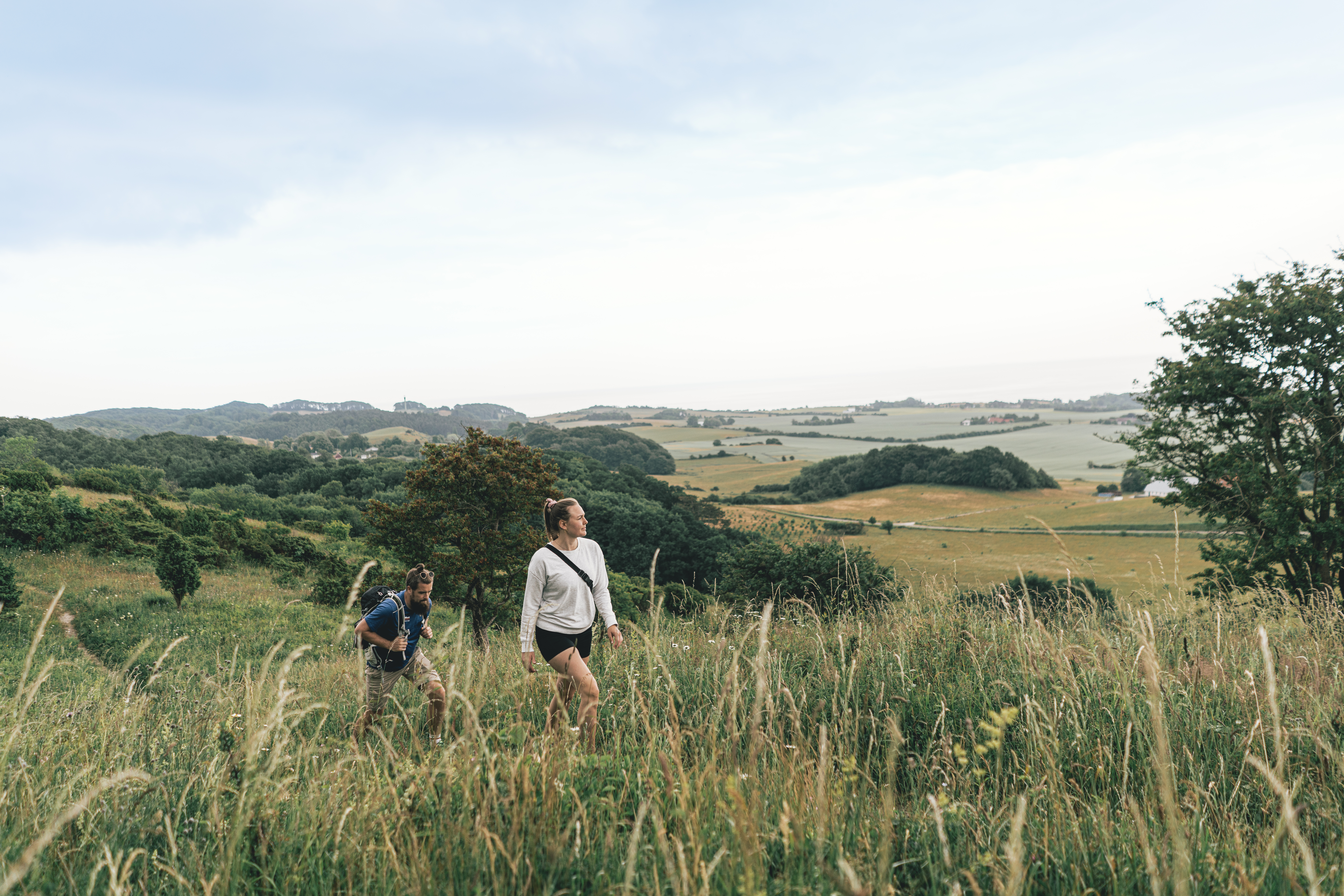 To personer som vandrer i kuperet terræn på Møn