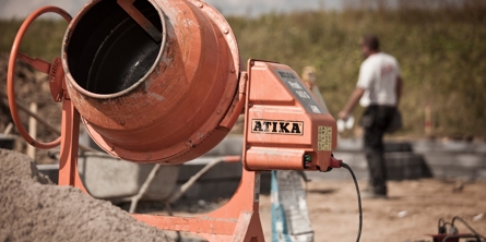 En cementblander med to arbejdsfolk i baggrunden