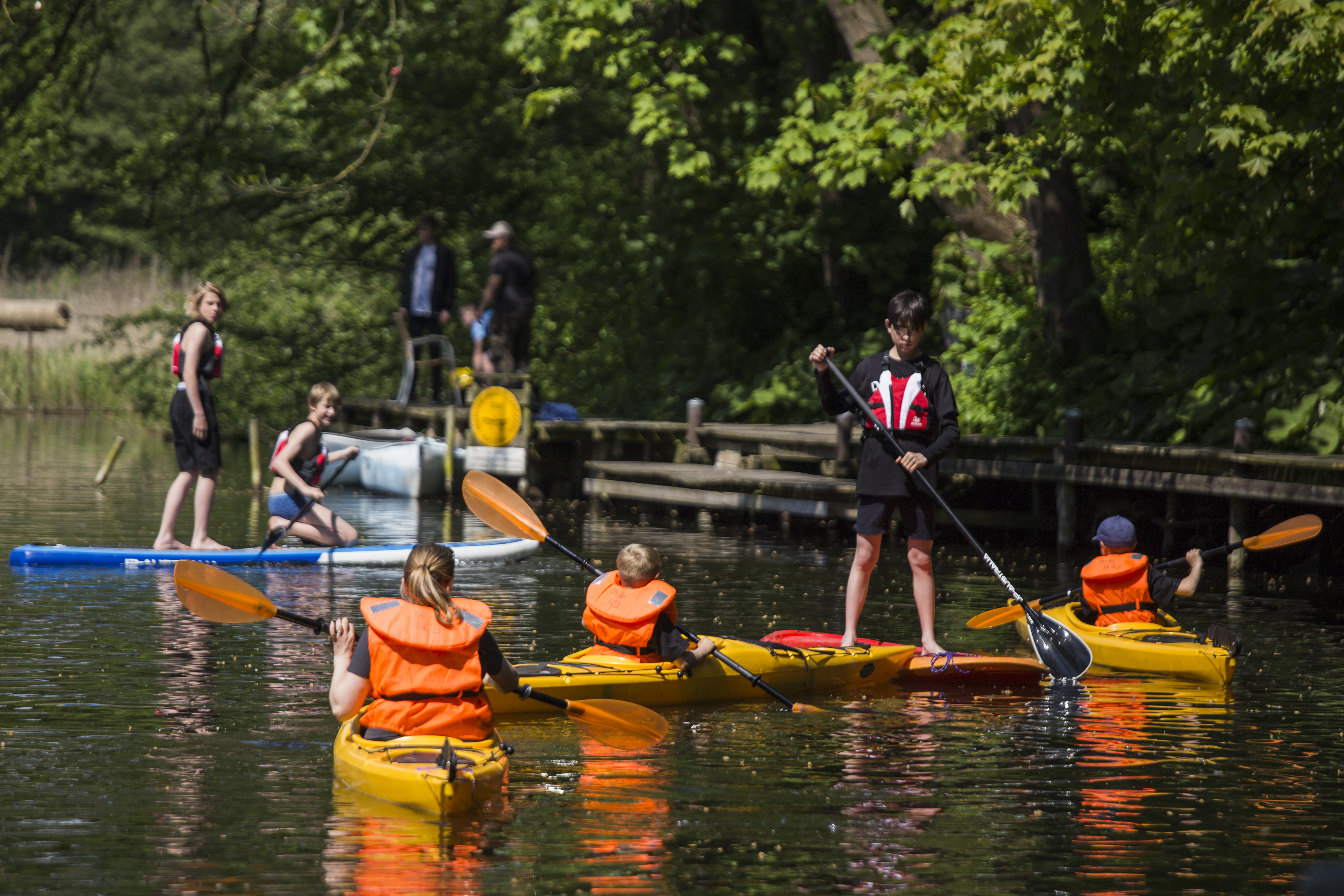 Stand up paddle board, kajakker og kanoer i å med personer.