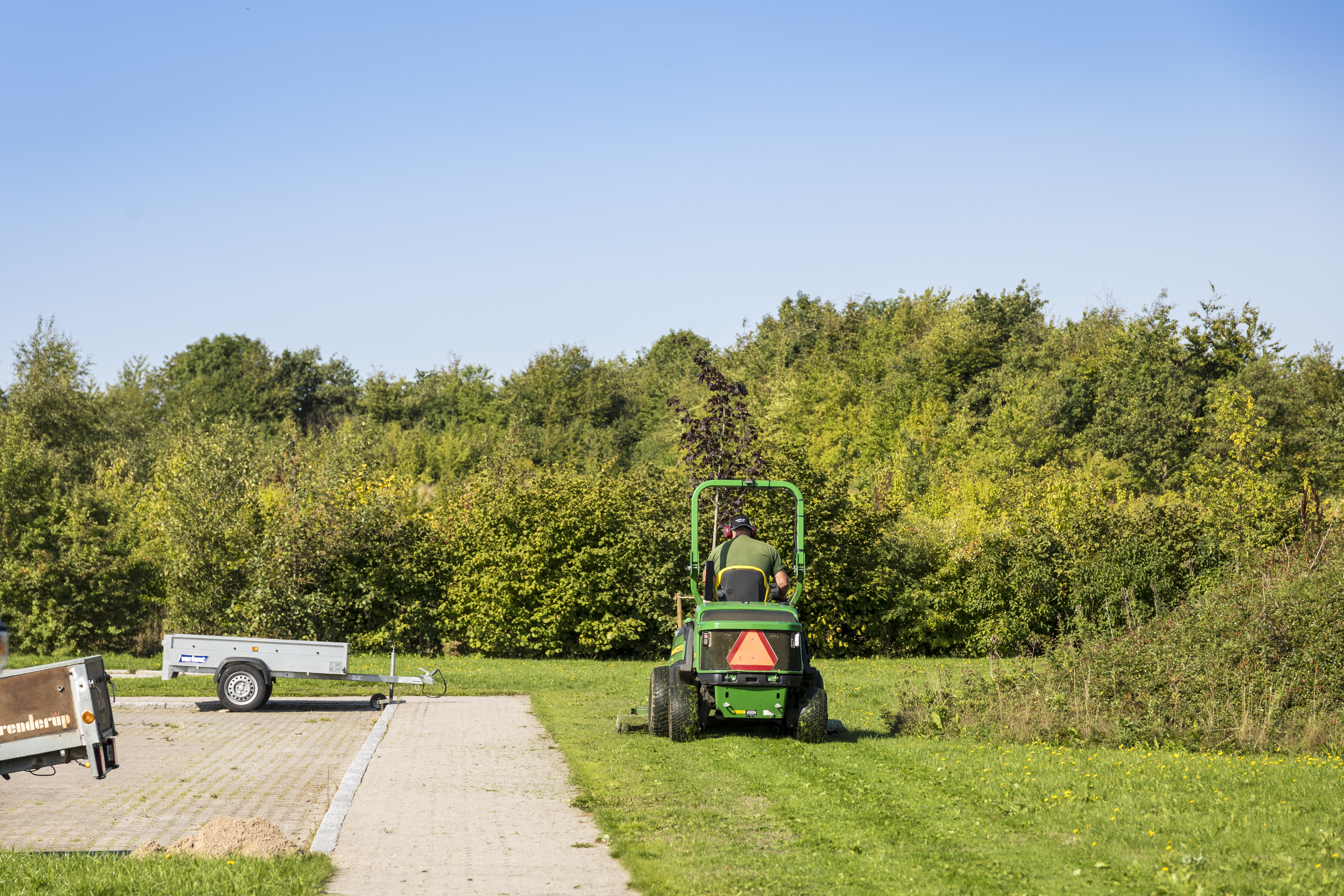 Græsplæne slås af græsslåningstraktor