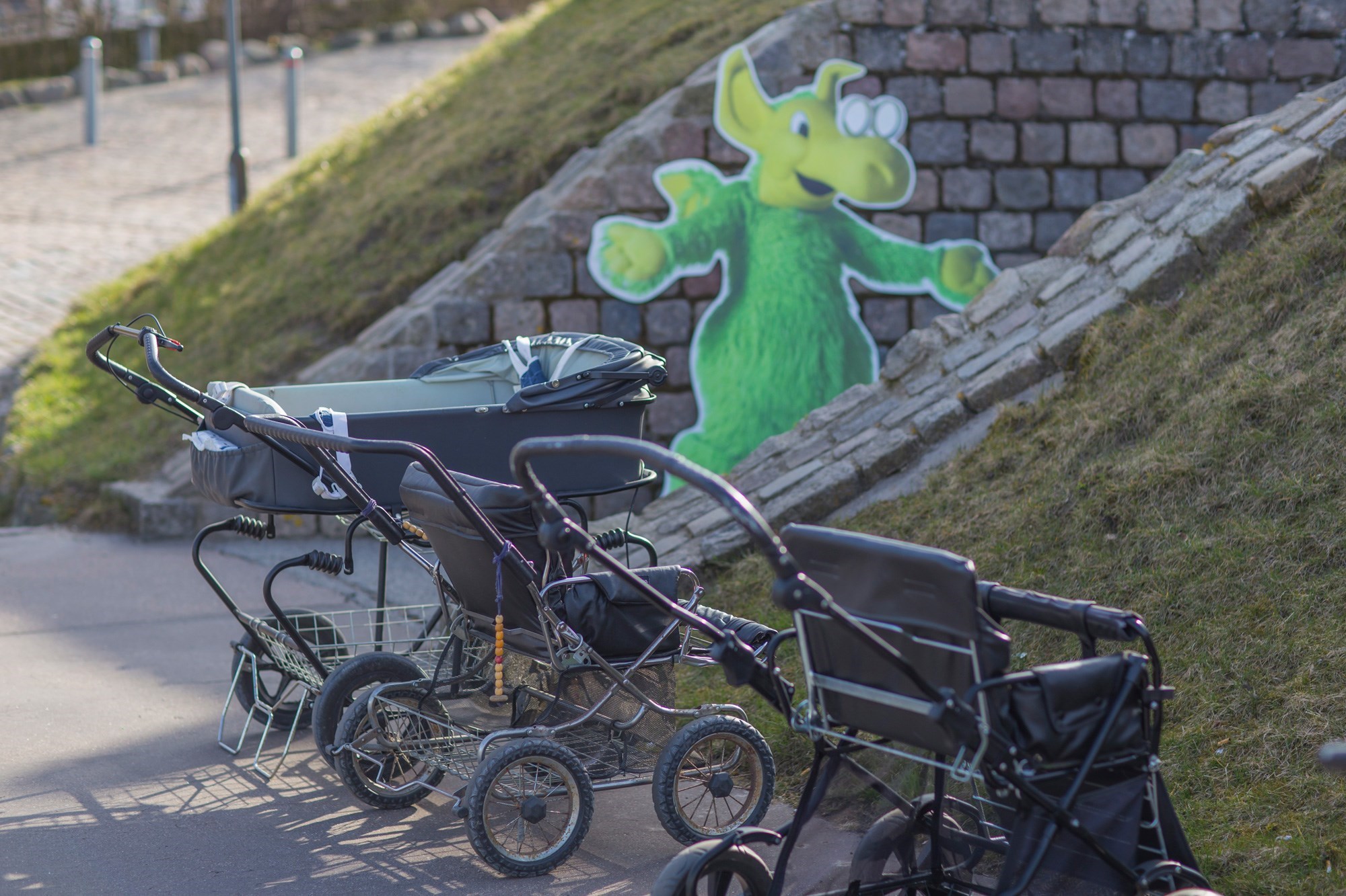 Barnevogne holder parkedede ved indgang hvor en Figur Af Næssie er stillet op til modtagelse