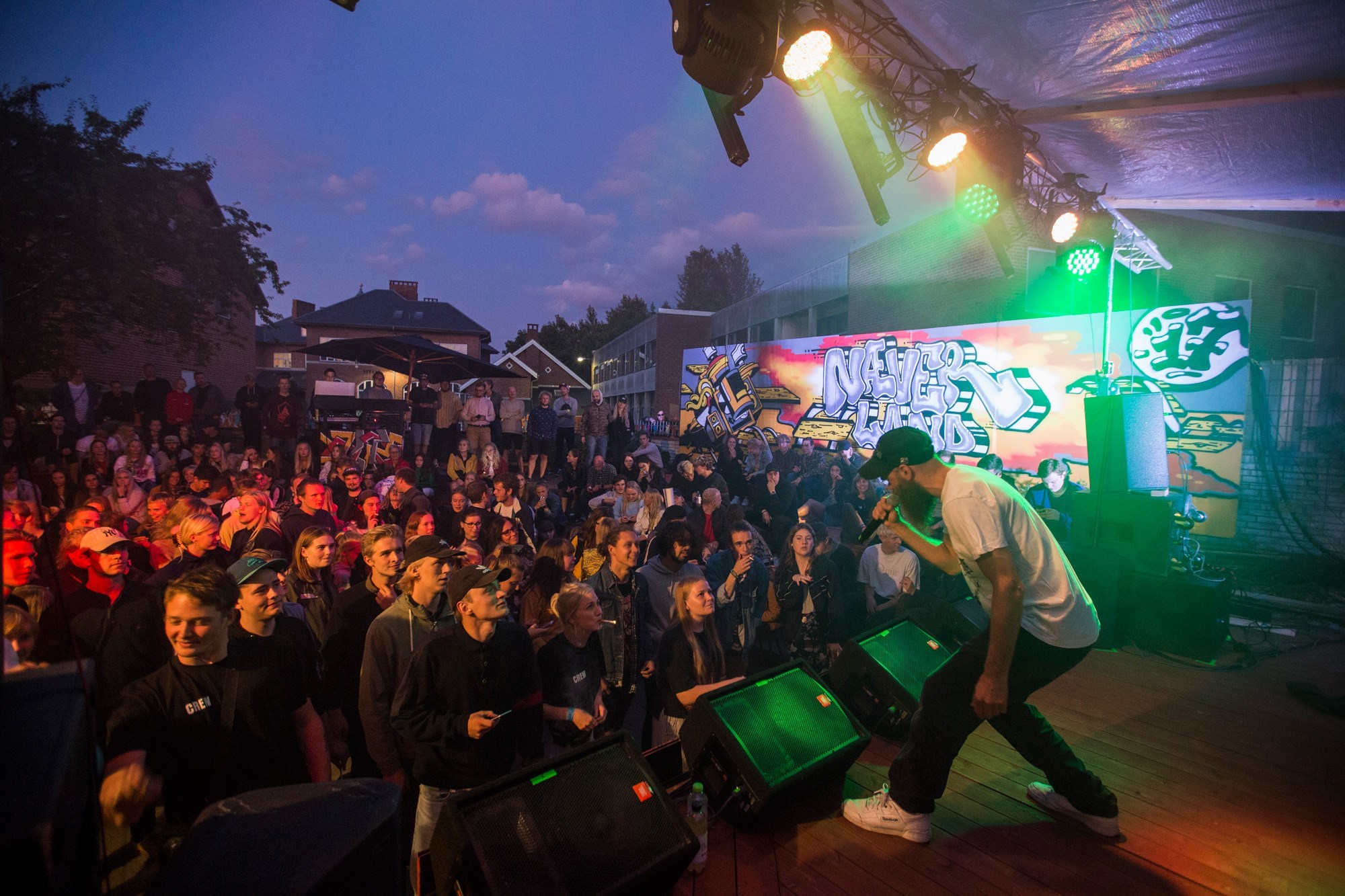 En mandlig sanger bukker sig frem mod publikum 