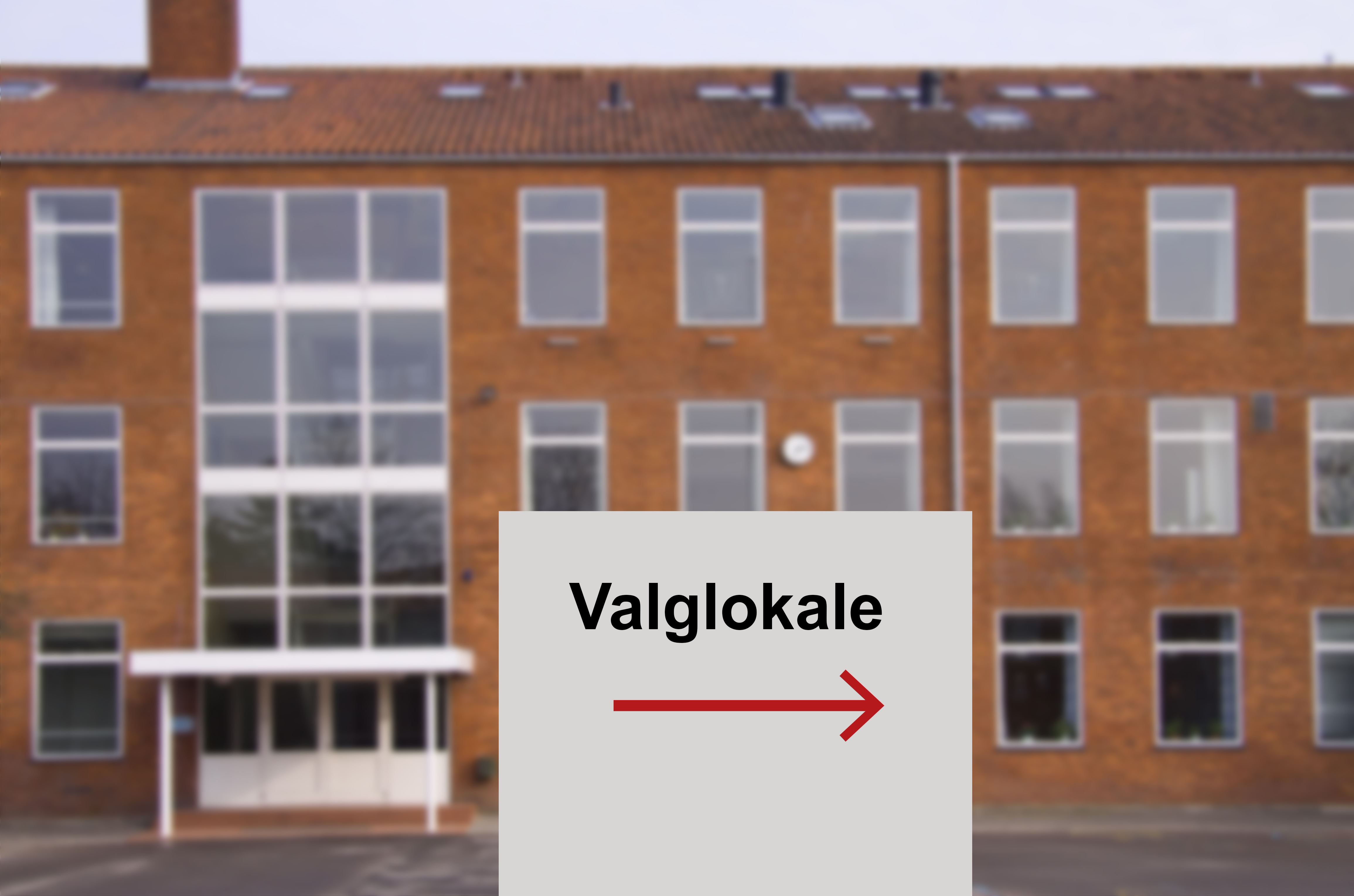 Billede af valgsted, hvor der er placeret et skilt med ordet valglokale og en pil