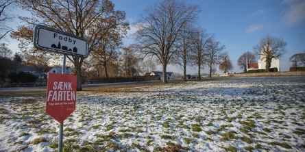 Fodby byskilt på snedækket landskab foran Fodby kirke