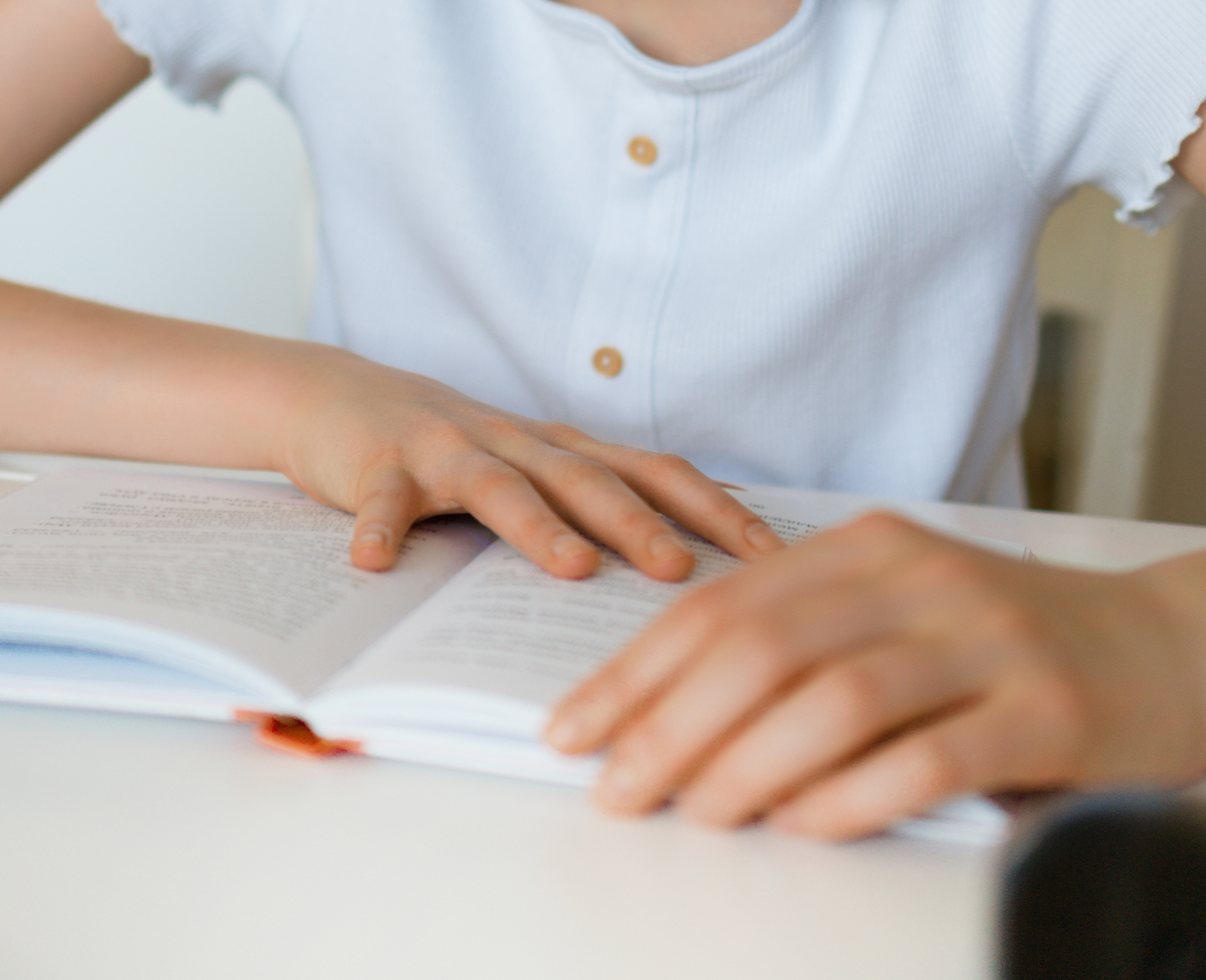 et barn der sidder med en åben bog mellem hænderne