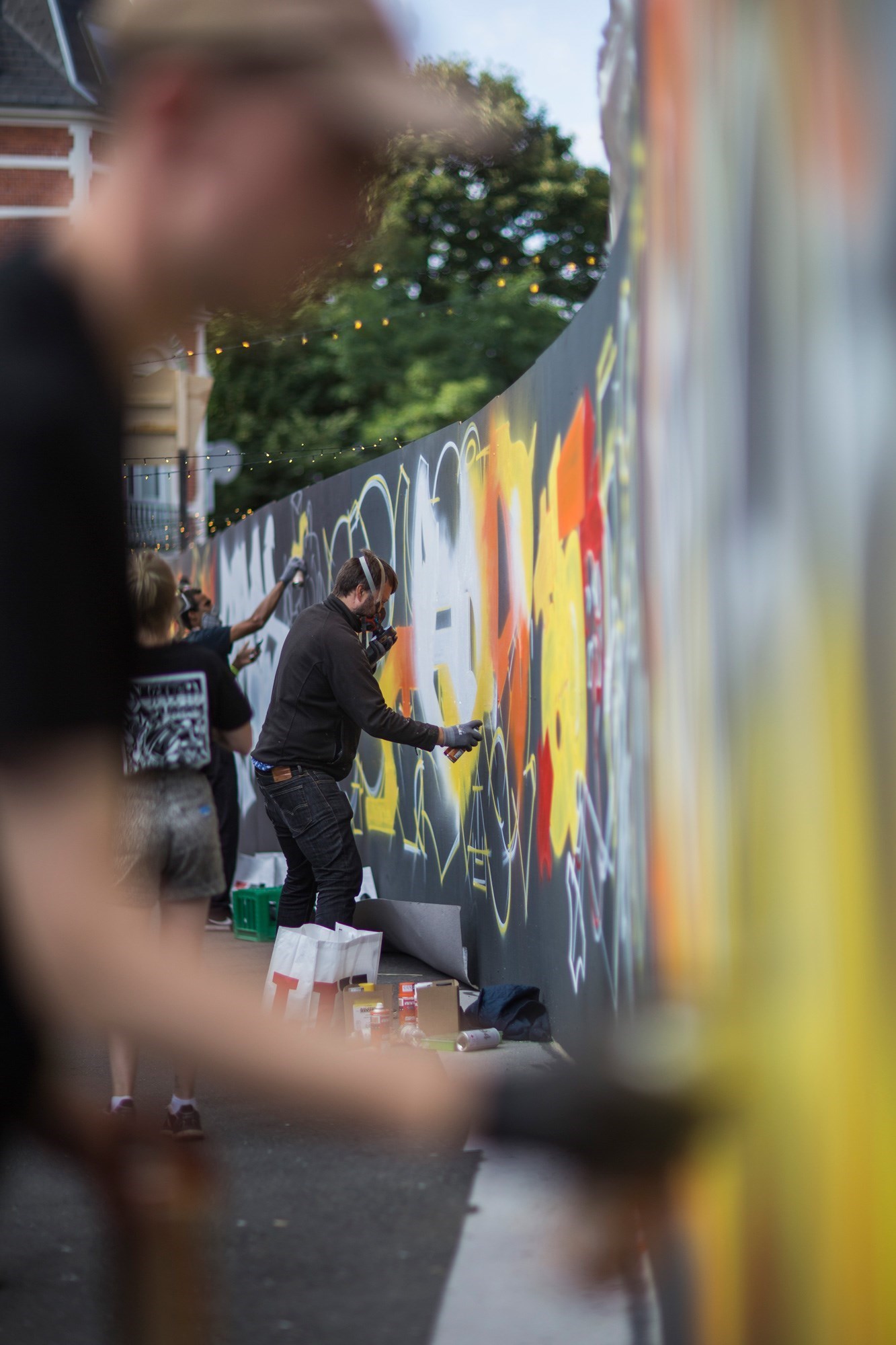 Flere kunstnere arbejder på en graffitivæg i Næstved bymidte