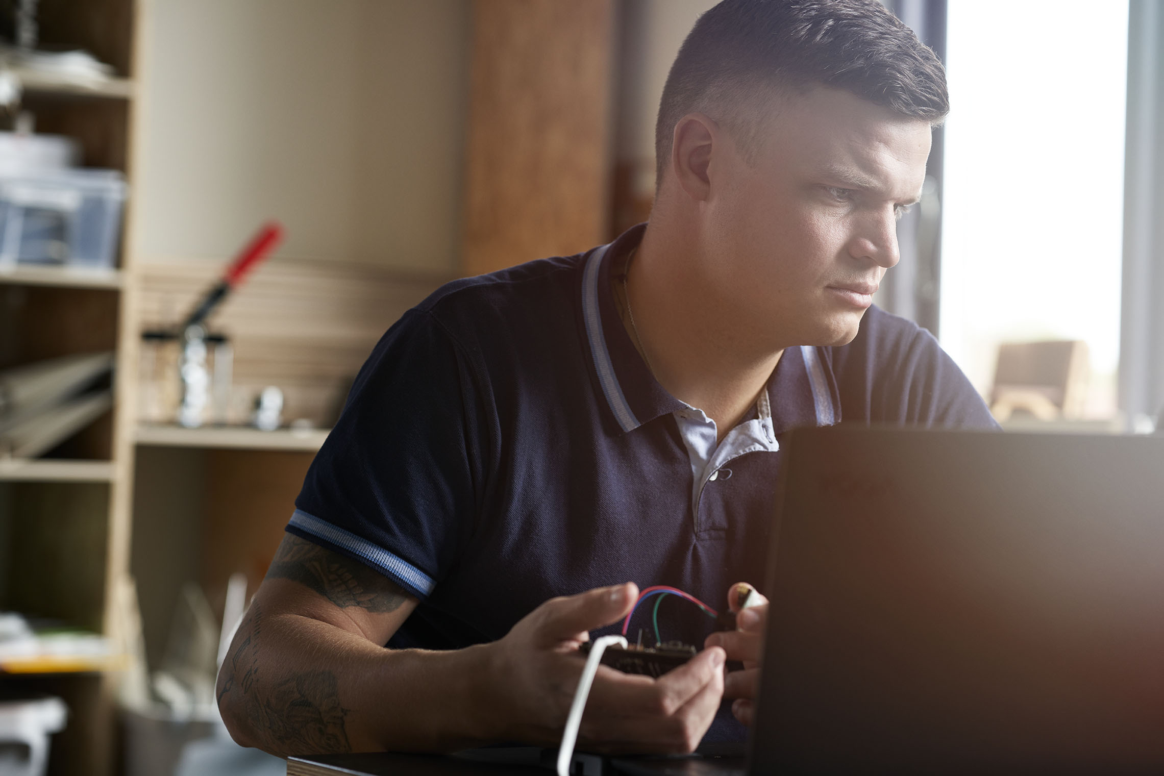 En mand sidder ved et bord med en computer 