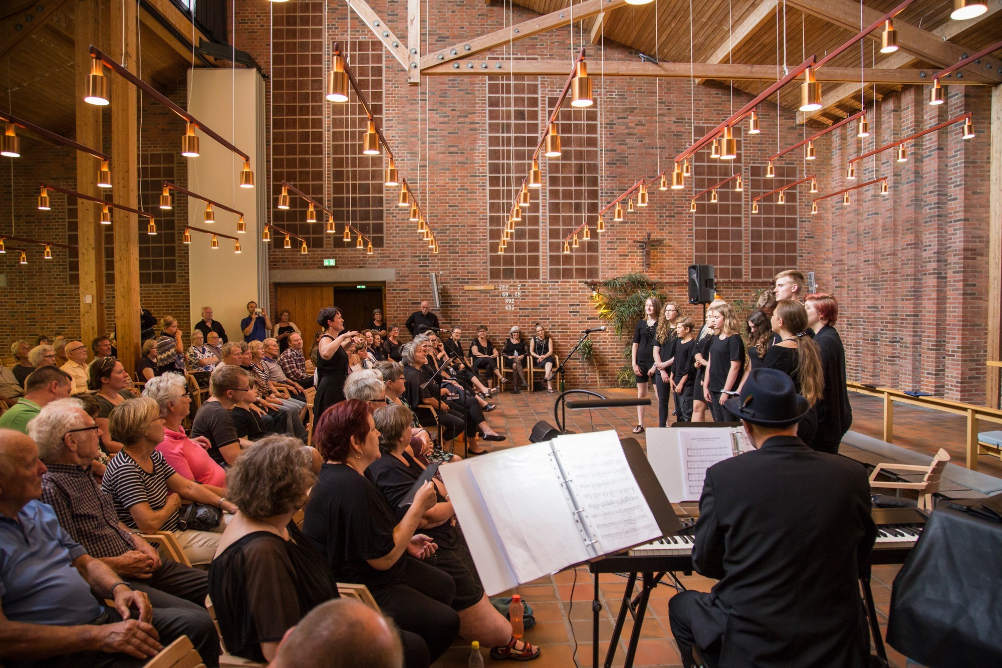 Et pigekor synger foran publikum i en kirke