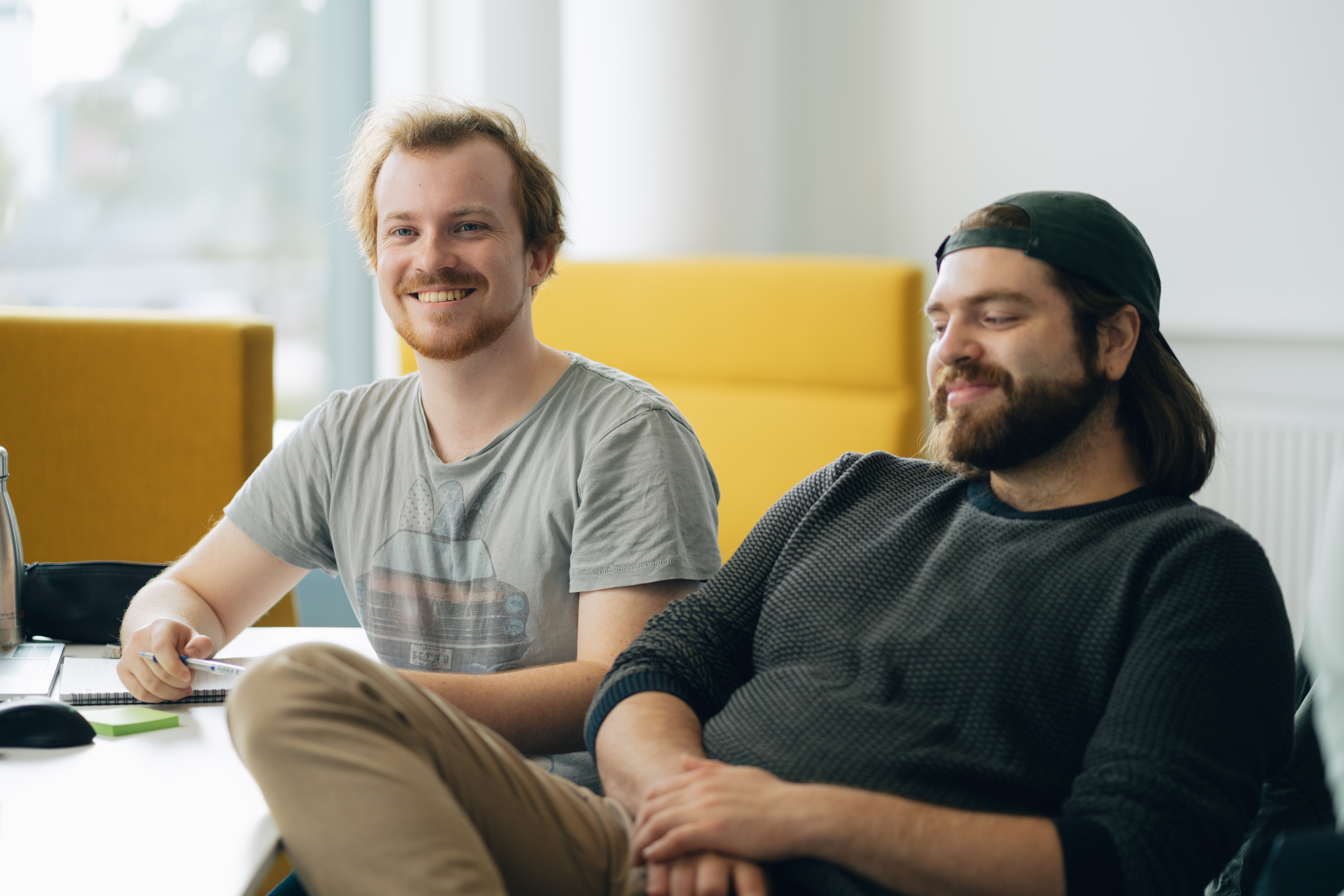 To glade mænd sidder lytter